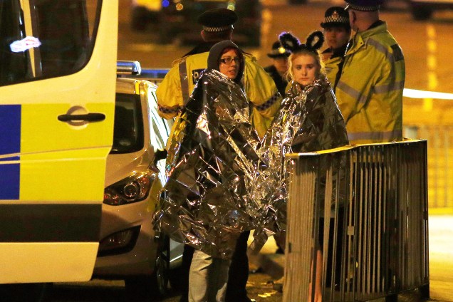 Fãs recebem assistência da polícia após explosão no show da cantora Ariana Grande que deixou ao menos 19 mortos e 50 feridos