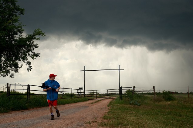O pesquisador <span>Hunter Anderson, do Centro de Pesquisa de Climas Intensos, corre de volta para o comboio, enquanto uma tempestade se aproxima de sua equipe, na região de Quanah, Texas</span>