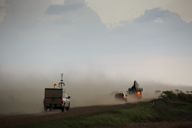 Comboio de carros escolta veículo equipado com equipamentos de meteorologia, durante uma perseguição a uma tempestade supercelular, em uma missão de pesquisa de tornados em Olustee, Oklahoma