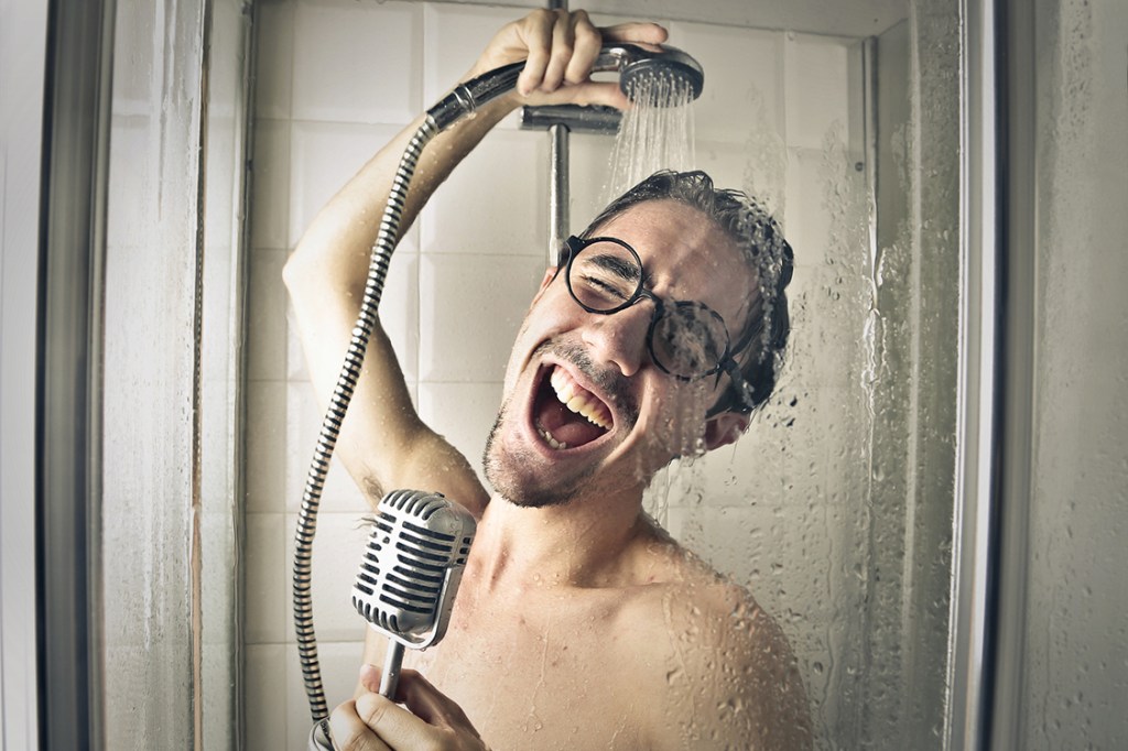 Homem cantando no chuveiro com um óculos??