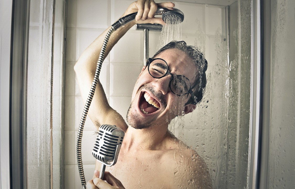 Homem cantando no chuveiro com um óculos??