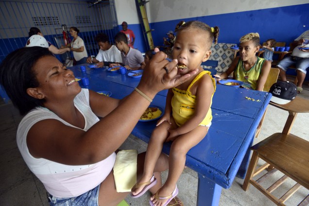 Moradora de Rio Formoso (PE) desabrigada devido a enchentes, alimenta criança