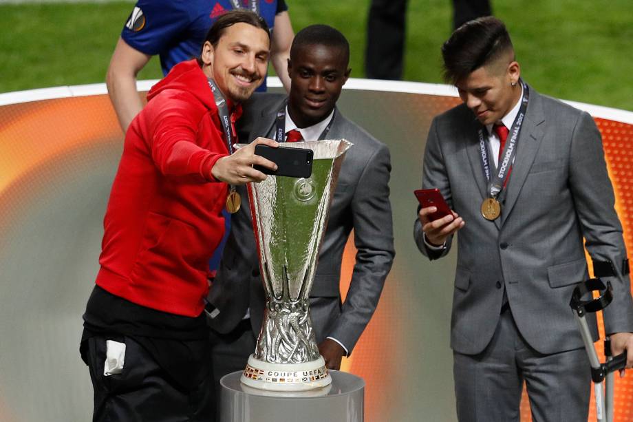 O atacante Zlatan Ibrahimovic do Manchester United faz uma selfie ao lado de Eric Bailly com a taça da Liga Europa - 24/05/2017