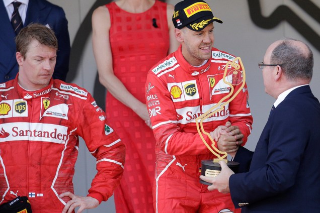 O piloto da Ferrari Sebastian Vettel recebe o troféu após superar o companheiro Kimi Raikkonen e vencer o GP de Mônaco
