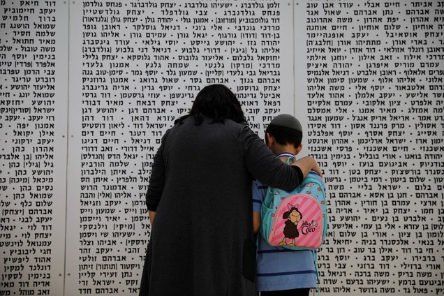 Uma mulher e um menino olham para um memorial em homenagem aos soldados mortos, em Israel