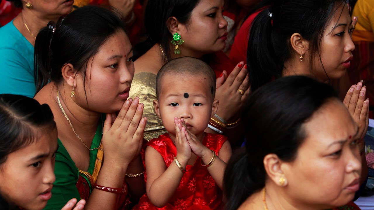 Imagens do dia - Criança participa das orações em um templo budista