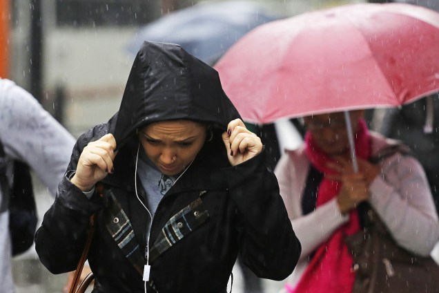 Chuva atrapalha trânsito e deixa SP em alerta para alagamentos. Pedestres se protegem da chuva e frio, na avenida Paulista em São Paulo - 19/05/2017
