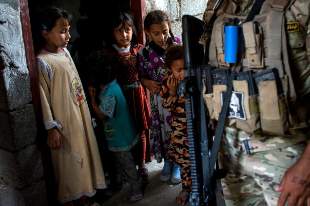 Crianças iraquianas confinadas por medo dos conflitos na cidade de Mosul são fotografadas na porta de sua casa durante ofensiva das forças iraquianas contra o Estado Islâmico no bairro al-Haramat, noroeste de Mosul - 11/05/2017