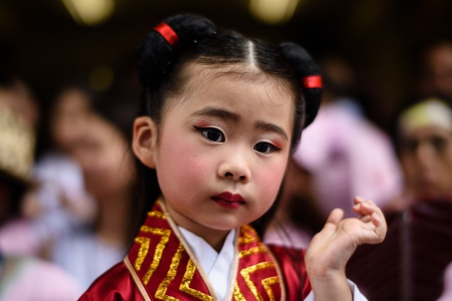 Menina vestida com trajes tradicionais participa do festival anual taoísta Cheung Chau Bun em Hong Kong - 03/05/2017