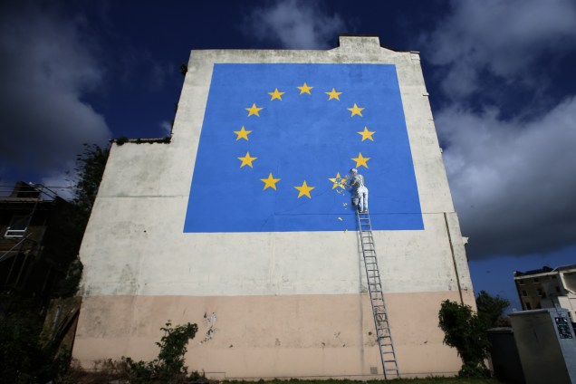 Mural pintado pelo artista britânico Banksy mostra um trabalhador quebrando uma das estrelas da bandeira da União Europeia em Dover, sudeste da Inglaterra - 08/05/2017