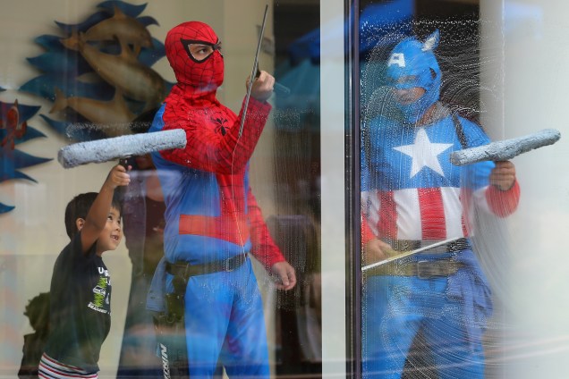 O pequeno Dominic, de quatro anos, ajuda os limpadores de janelas vestidos de super-heróis enquanto trabalham no Rady Children's Hospital em San Diego, na Califórnia (EUA). O menino acompanha o irmão que fez uma cirurgia na cabeça e está em recuperação - 30/05/2017