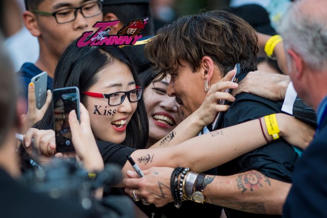 O ator Johnny Depp é abraçado por fãs durante evento de estreia mundial do filme 'Piratas do Caribe: A Vingança de Salazar', em Xangai, na China - 11/05/2017