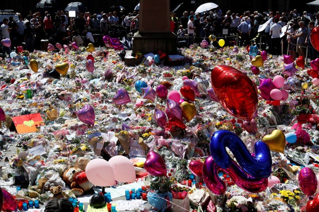 Pessoas observam tributo feito em homenagem às vítimas do atentado em Manchester, na Inglaterra, durante show da cantora Ariana Grande. 19 pessoas morreram e 50 ficaram feridas - 26/05/2017