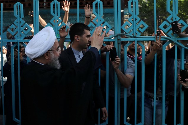 Presidente do Irã, Hassan Rouhani, cumprimenta eleitores em uma estação de votação em Teerã - 19/05/2017