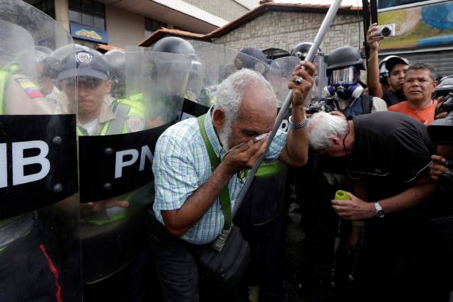 Idosos cobrem o rosto após serem atingidos com gás de pimenta pulverizado por policiais durante manifestação contra o presidente Nicolás Maduro em Caracas, Venezuela - 12/05/2017 Idosos cobrem o rosto após serem atingidos com gás de pimenta pulverizado por policiais durante manifestação contra o presidente Nicolás Maduro em Caracas, Venezuela - 12/05/2017