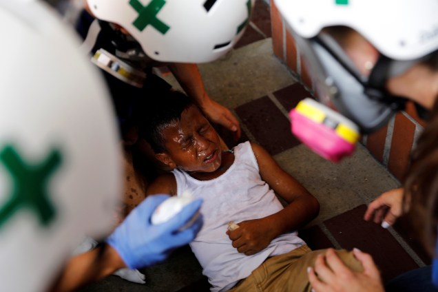 Equipe primeiros-socorros atende uma criança ferida durante manifestação contra o presidente Nicolás Maduro em Caracas, na Venezuela - 24/05/2017