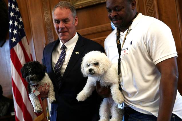 Ryan Zike, Secretário do Interior dos Estados Unidos, posa em seu escritório com seu cão Ragnar e com o funcionário da Casa Branca Torry Teryll, que levou seu poodle Chico para o trabalho durante o primeiro evento de "Leve seu cão para o trabalho", organizado pela Secretaria do Interior americana - 05/05/2017