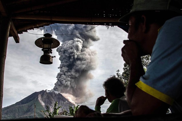 Família observa o Monte Sinabung expelir cinzas no distrito de Karo, na província de Sumatra do Norte, na Indonésia - 19/05/2017