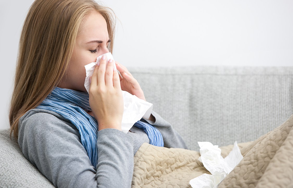 Infecção respiratória: mulher assoando o nariz