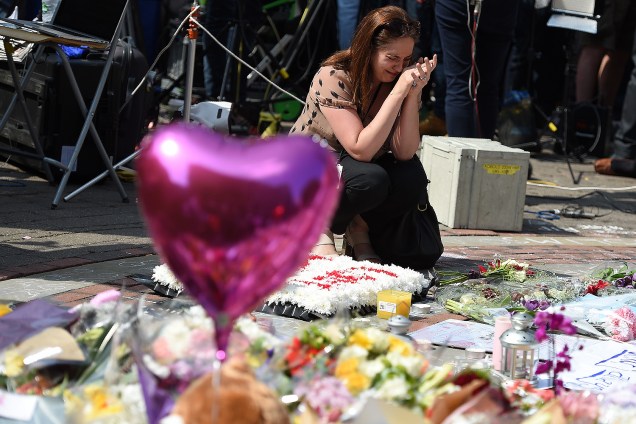 Mulher presta um minuto de silêncio no centro da cidade de Manchester em memória aos mortos no ataque terrorista durante show na Manchester Arena - 25/05/2017