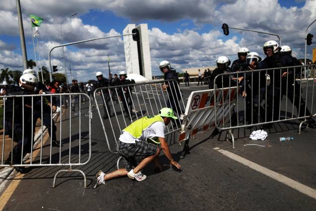 Manifestante tenta ultrapassar uma barricada durante protesto que pede a saída do presidente Michel Temer, em Brasília (DF) - 24/05/2017
