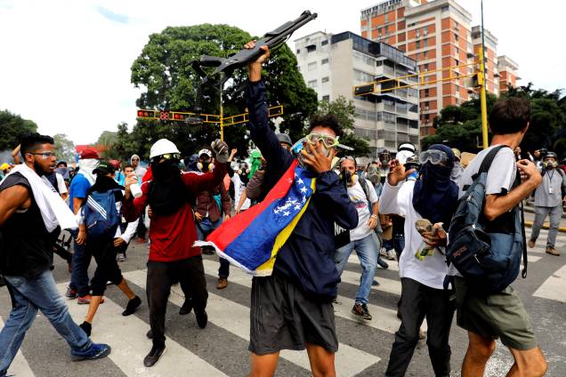 Manifestante da oposição ao Presidente Nicolás Maduro toma da polícia uma arma durante confronto no protesto em Caracas, na Venezuela - 03/05/2017