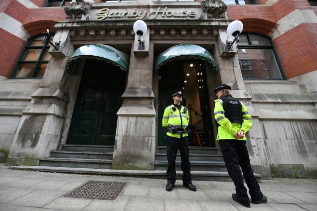 Policiais ficam de plantão em frente ao edifício de apartamentos Granby House em Manchester, durante investigações sobre o ataque terrorista durante um show da cantora Ariana Grade na Manchester Arena - 24/05/2017