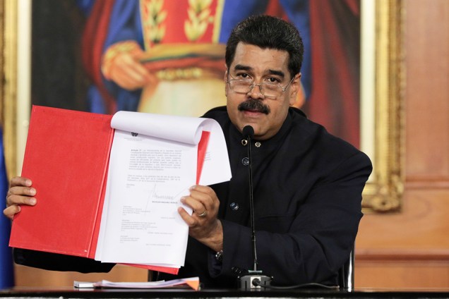 O  presidente da Venezuela, Nicolás Maduro, mostra um documento durante cerimônia no Palácio de Miraflores, em Caracas, na Venezuela