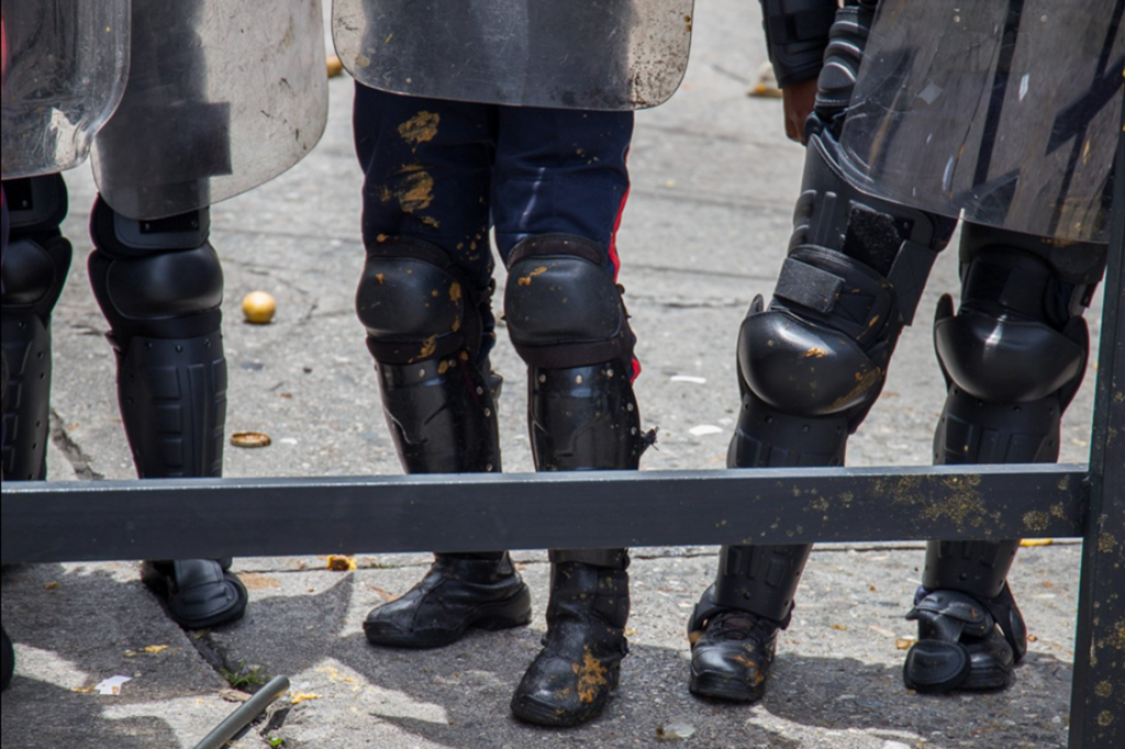 Durante protesto contra o governo venezuelano, manifestantes jogam excrementos nos policiais, em Caracas