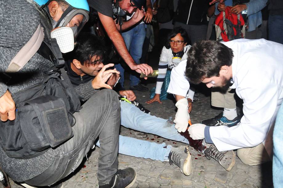 Manifestante é socorrido por médicos após levar um tiro de bala de borracha durante protesto contra o presidente Michel Temer no centro do Rio de Janeiro (RJ) - 18/05/2017