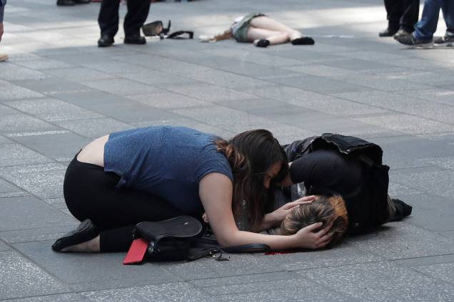 Mulher ajuda uma pessoa ferida depois que um veículo atingiu pedestres em uma calçada na região da Times Square, em Nova York -18/05/2017 Mulher ajuda uma pessoa ferida depois que um veículo atingiu pedestres em uma calçada na região da Times Square, em Nova York -18/05/2017