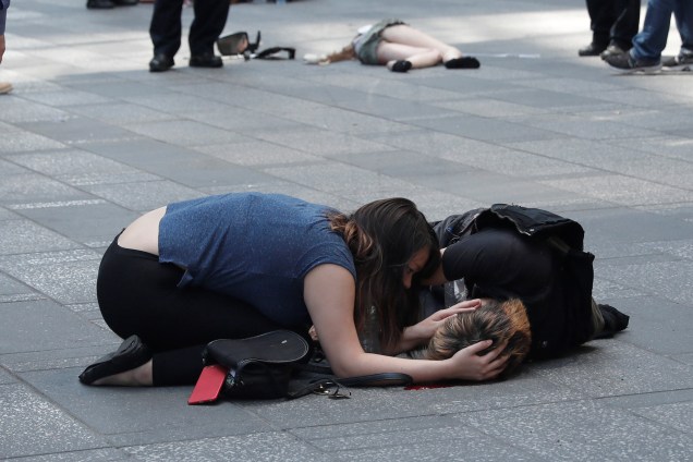 Mulher ajuda uma pessoa ferida depois que um veículo atingiu pedestres em uma calçada na região da Times Square, em Nova York -18/05/2017