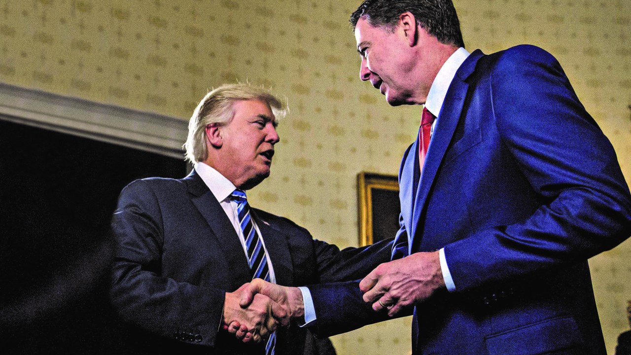 O presidente americano Donald Trump cumprimenta o chefe do FBI James Comey logo após tomar posse, em janeiro de 2017