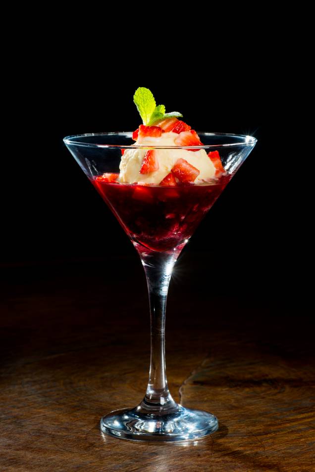 Sobremesa para o almoço: sorvete artesanal de vanilla com calda de frutas vermelhas e morangos frescos Sobremesa para o almoço: sorvete artesanal de vanilla com calda de frutas vermelhas e morangos frescos
