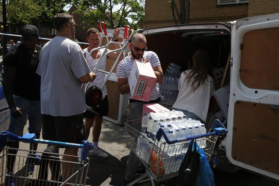 Mantimentos são descarregados de uma van para auxiliar os afetados pelo incêndio no edifício Grenfell Tower, em Londres - 14/06/2017