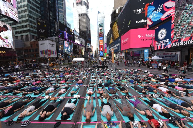 Americanos se reúnem durante evento anual de ioga na Times Square, em comemoração do solstício de verão, em Nova York - 21/06/2017