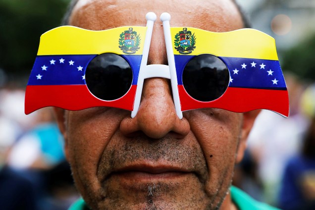 Um homem usa óculos com bandeira do país em novo protesto contra o presidente Nicolás Maduro, em Caracas, na Venezuela - 07/06/2017
