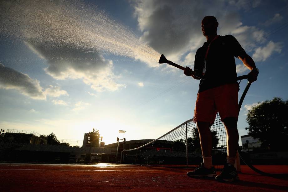 Funcionário molha o saibro de uma das quadras do complexo que abriga o torneio de Roland Garros em Paris, na França - 31/05/2017