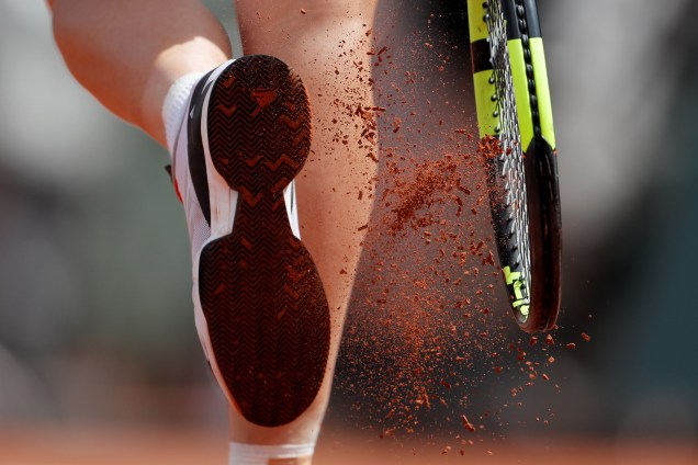 A dinamarquesa Caroline Wozniacki tira o excesso de saibro de seu tênis durante partida contra Jelena Ostapenko da Letônia, válida pelas quartas de final do torneio de Roland Garros - 04/06/2017