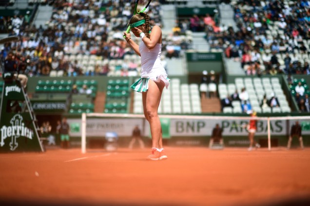 A tenista Jelena Ostapenko da Letônia sofre com a poeira soprada pelo vento durante sua partida contra a dinamarquesa Caroline Wozniacki - 06/06/2017