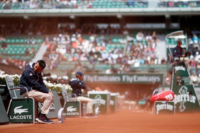 Juízes de linha são atingidos pela poeira trazida pelo vento durante partida entre a francesa Kristina Mladenovic e a suíça Timea Bacsinszky, válida pelas quartas de final do torneio de Roland Garros - 06/06/2017