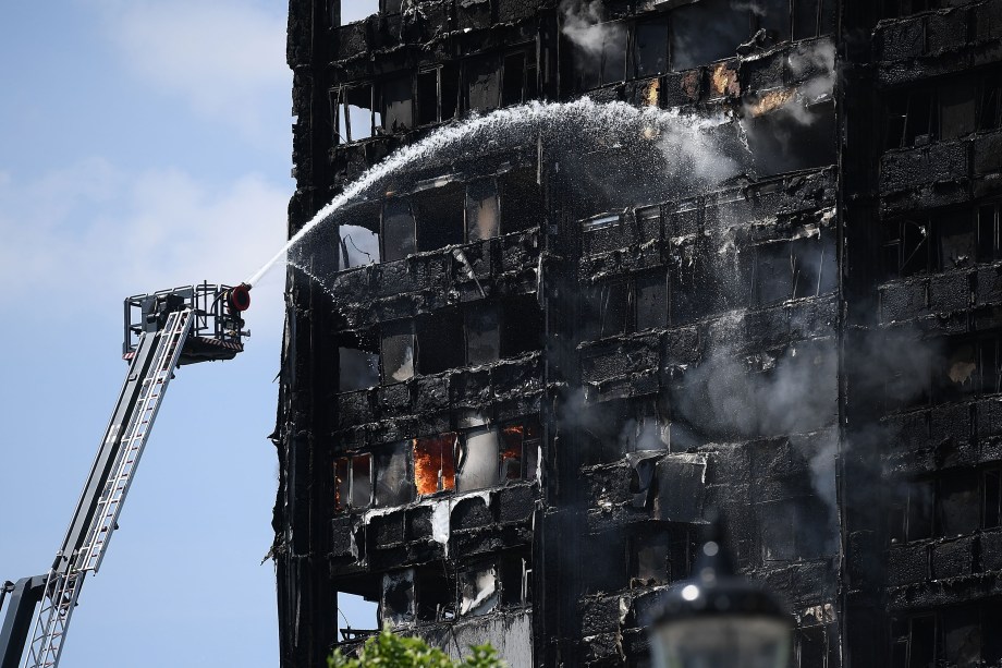 Bombeiros jogam jatos de água para conter as chamas do prédio Grenfell Tower que se iniciou esta manhã na zona oeste de Londres -14/06/2017