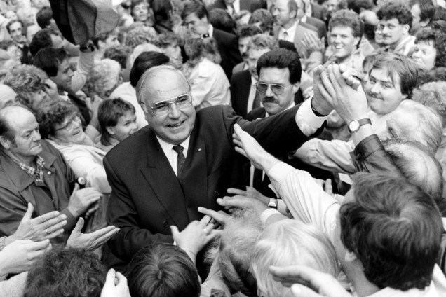 O chanceler alemão Helmut Kohl é saudado pela multidão reunida na Praça da Paz durante primeiro encontro de eleições em 1990