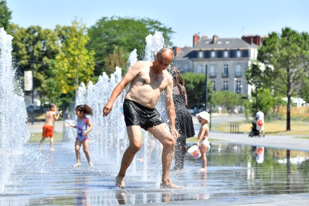 Franceses se refrescam em praça pública após a meteorologia dar estado de alerta laranja para 16 regiões com ondas de calor, em Nantes, no oeste da França - 19/06/2017