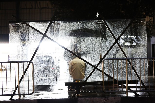 Pedestre se protege da chuva em ponto de ônibus na avenida Rio branco, na região central de São Paulo (SP) - 05/06/2017