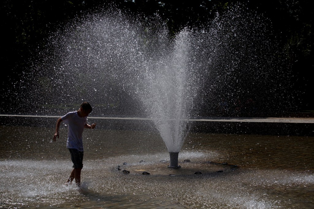 Turista aproveita chafariz para se refrescar durante uma onda de calor em Madri, na Espanha