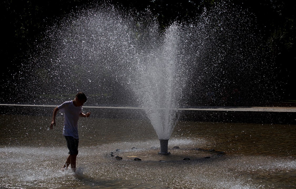 Turista aproveita chafariz para se refrescar durante uma onda de calor em Madri, na Espanha