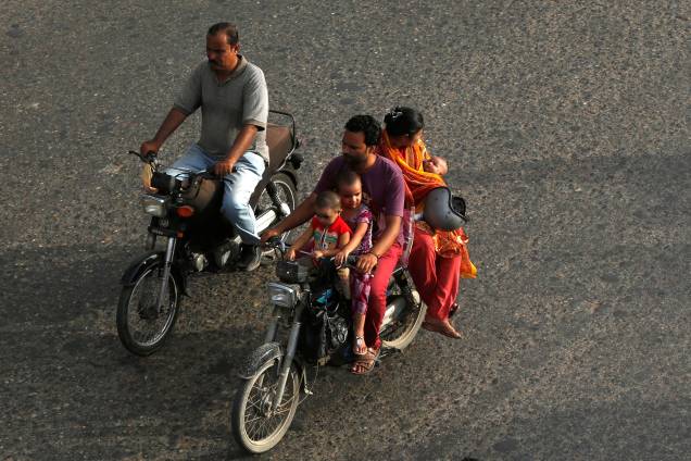 Homem leva a família em uma motocicleta em uma estrada de Karachi, no Paquistão - 13/06/2017