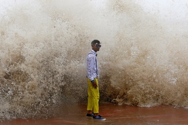 Jovem posa para uma fotografia durante uma maré alta em Mumbai, na Índia - 27/06/2017
