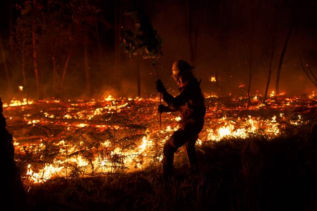 Bombeiro da Guarda Nacional Republicana tenta controlar um incêndio em uma floresta em Pedrógão Grande, no distrito de Leiria, em Portugal. Incêndios na região central do país deixaram ao menos 64 mortos - 19/06/2017 Bombeiro da Guarda Nacional Republicana tenta controlar um incêndio em uma floresta em Pedrógão Grande, no distrito de Leiria, em Portugal. Incêndios na região central do país deixaram ao menos 64 mortos - 19/06/2017